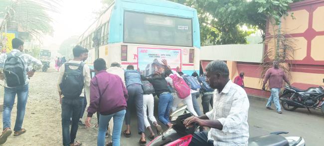 ರಸ್ತೆ ಮಧ್ಯ ಬಂದು ಬಿದ್ದ ಬಸ್‌: ಬಸ್ ತಳ್ಳುತ್ತಿರುವ ಶಾಲಾ ವಿದ್ಯಾರ್ಥಿಗಳು 